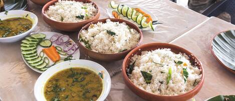 A table with various dishes including rice, curry, and vegetables.