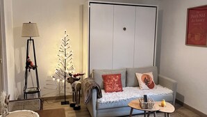 Una sala de estar acogedora con un sofá, una mesita, una lámpara y una planta decorativa.