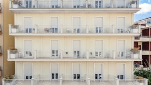 A multi-story hotel with balconies, a sign reading "HOTEL PLAZA," and outdoor seating areas. - Hotel Plaza Gabicce Mare (Gabicce Mare)