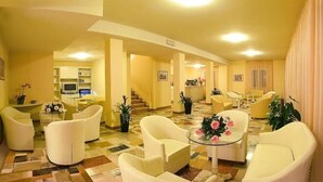 A spacious hotel lobby with a central seating area, a reception desk, and a staircase leading to other floors. - Hotel Plaza Gabicce Mare (Gabicce Mare)