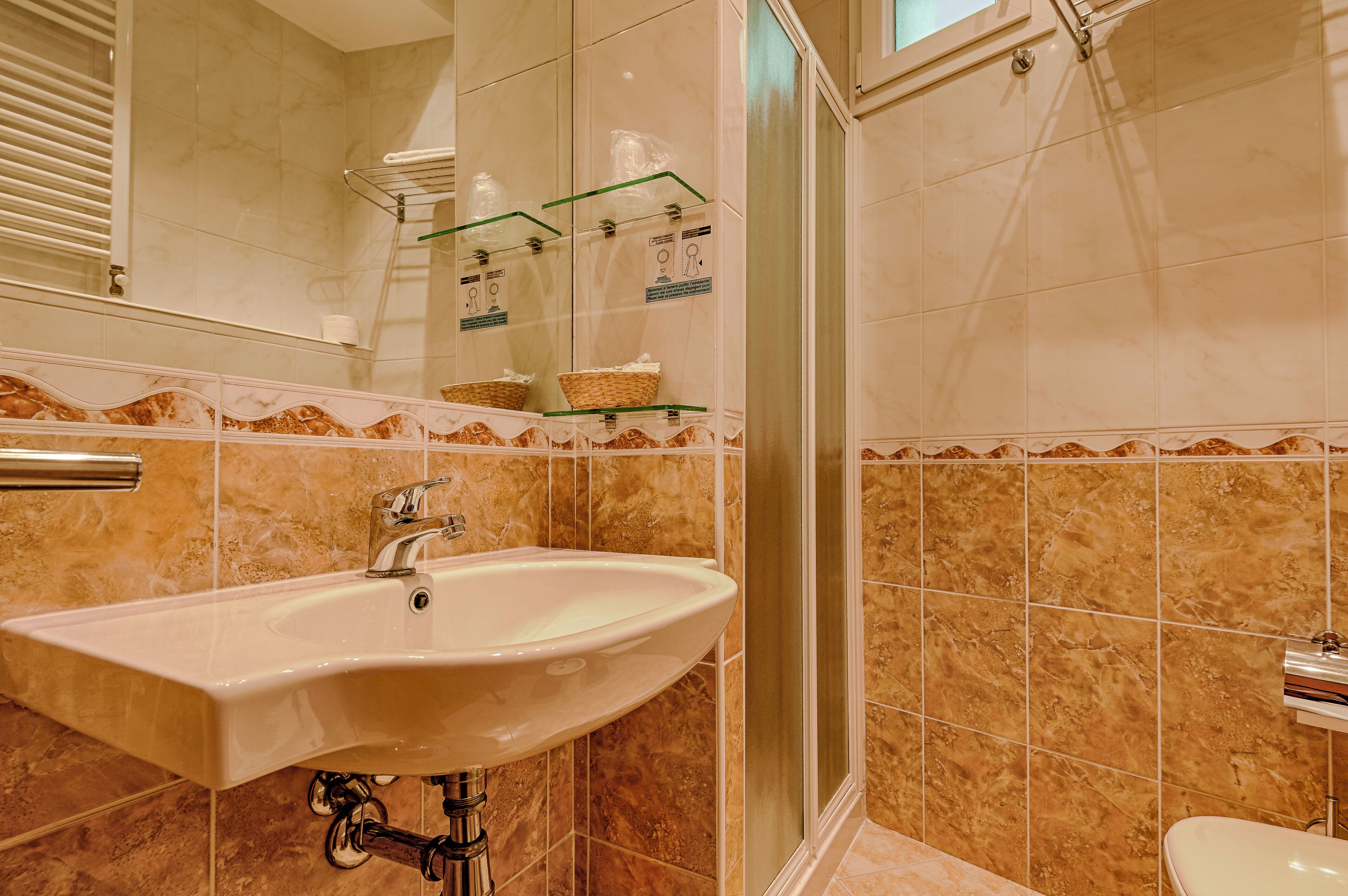 A bathroom with a sink, mirror, and shower.