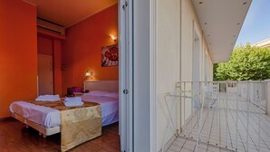 A bedroom with a bed, a bedside table, and a window. - Hotel Plaza Gabicce Mare (Gabicce Mare)
