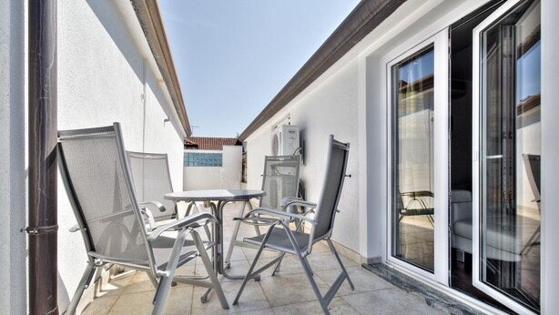 A patio with a table and chairs, a sliding glass door, and a tiled floor. - Cosy studio apartment for 2 on a great location in a touristic village, Susanna1 (Katoro)