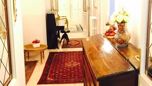 A narrow hallway with a wooden desk, a vase with flowers, and a framed picture on the wall. - Ch Colosseum home (Rome)
