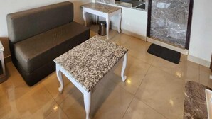 Una stanza con soffitto in legno, un divano, un tavolino e uno specchio.