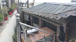 Una scala che conduce a un edificio con tetto in metallo e pareti in pietra.