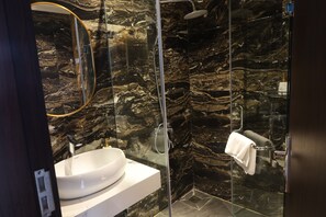 Habitación junior doble, vistas a la ciudad | Baño | Ducha, artículos de higiene personal gratuitos y secador de pelo