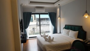 A hotel room with a large bed, a view of the city through a balcony, and a modern design. - Maya Central Hotel & Spa (Hanoi)