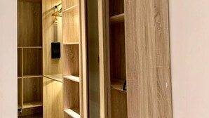 A wooden closet with multiple shelves and a sliding door. - Sujimoto luxury  (Lagos)