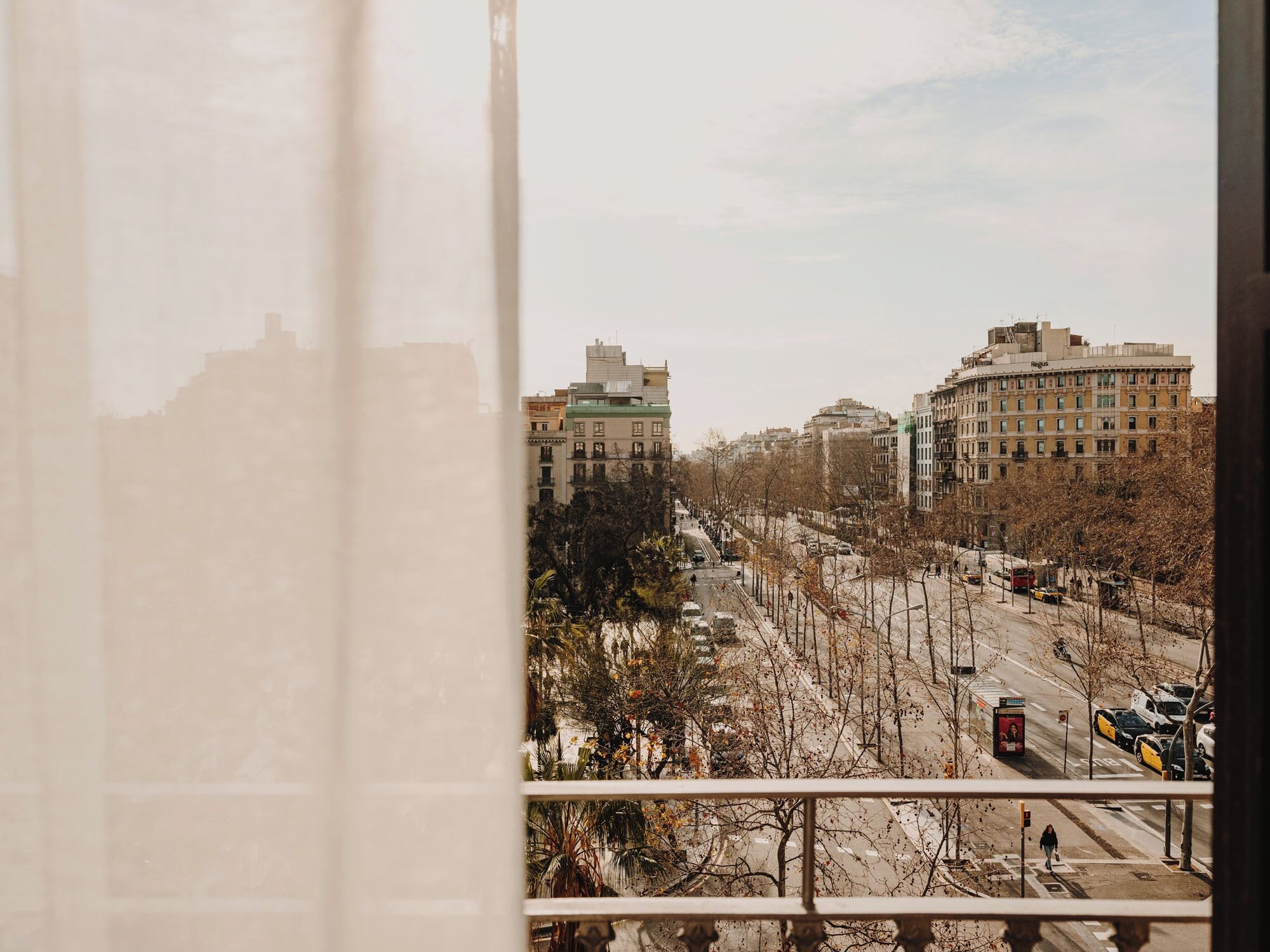Paisatge urbà amb edificis, un carrer i un pas de vianants.