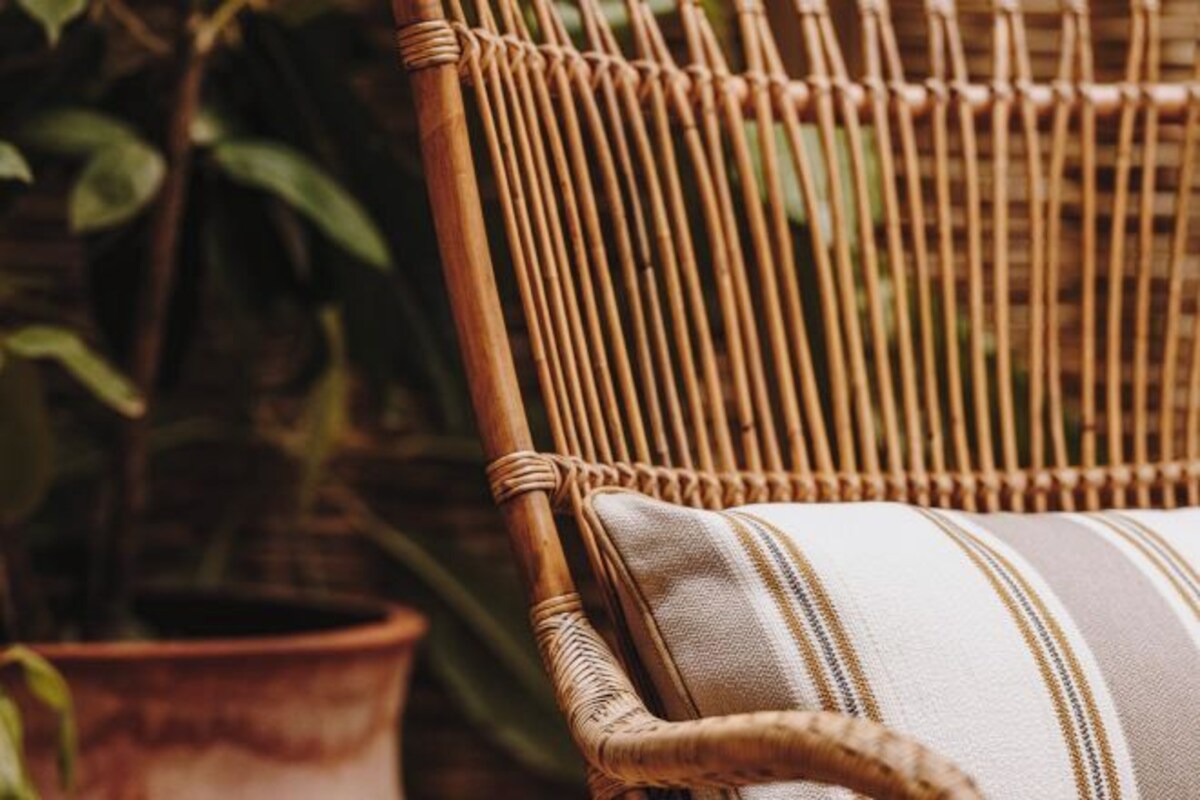 A wicker chair with a striped cushion.