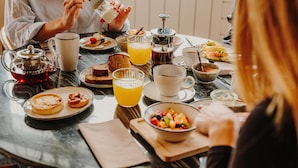 A breakfast setting with a variety of food items and beverages on a table.