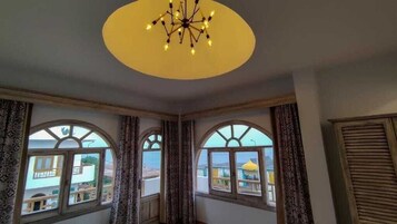 A room with arched windows, a chandelier, and curtains.