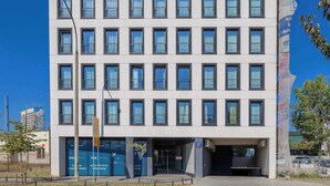 Ein modernes Hotel mit einer symmetrischen Fassade, zahlreichen Fenstern und einem markanten Eingang.