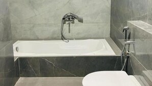 A bathroom with a bathtub, toilet, and a shower area. - HOTEL SAWARIYA (Ahmedabad)