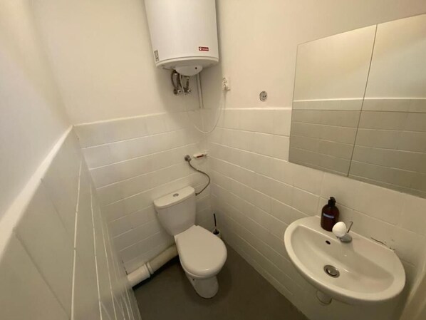 A small, white-walled bathroom with a toilet, bidet, and sink. - Fantastic Inn Warsaw - NS27 (Warsaw)