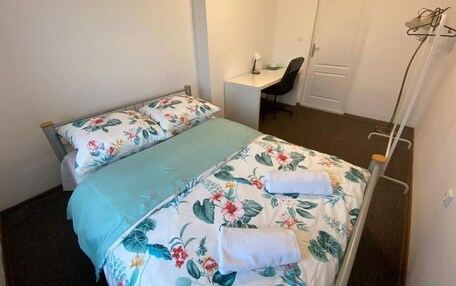 A bedroom with two beds, a desk, and a chair.