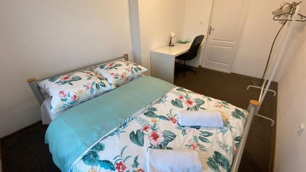 Ein Schlafzimmer mit zwei Betten, einem Schreibtisch und einem Stuhl.