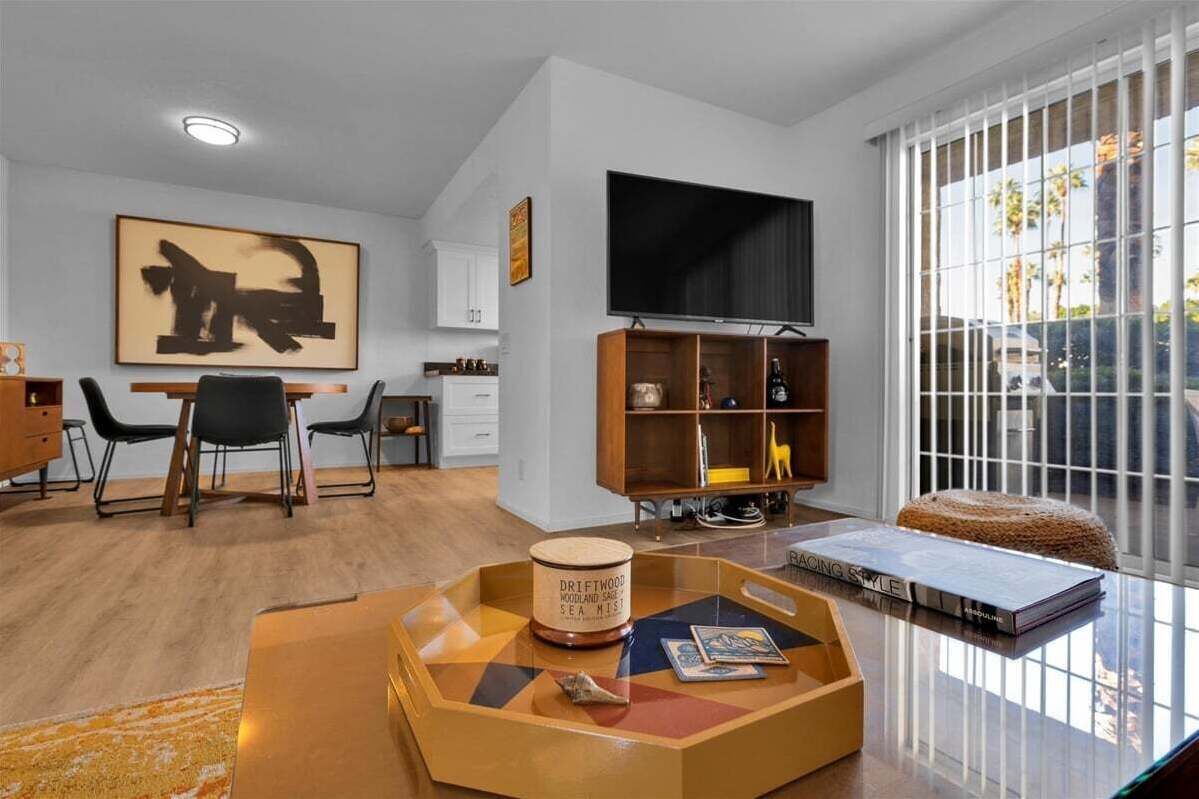 A modern living room with a dining area, a TV, and a bookshelf.