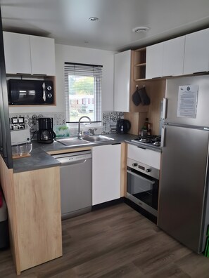 Fridge, microwave, oven, stovetop - Mobile Home “Mh 338 Ronce Les Bains” with Shared Pool, Private Terrace & Air Conditioning (La Tremblade)