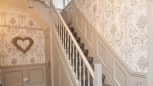 Una scala con balaustre bianche e una decorazione a forma di cuore sulla parete.