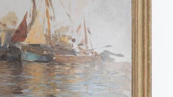 Un tableau encadré représentant un port avec des bateaux et de l’eau.