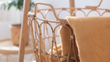 A wicker basket with a beige towel on a wooden surface.