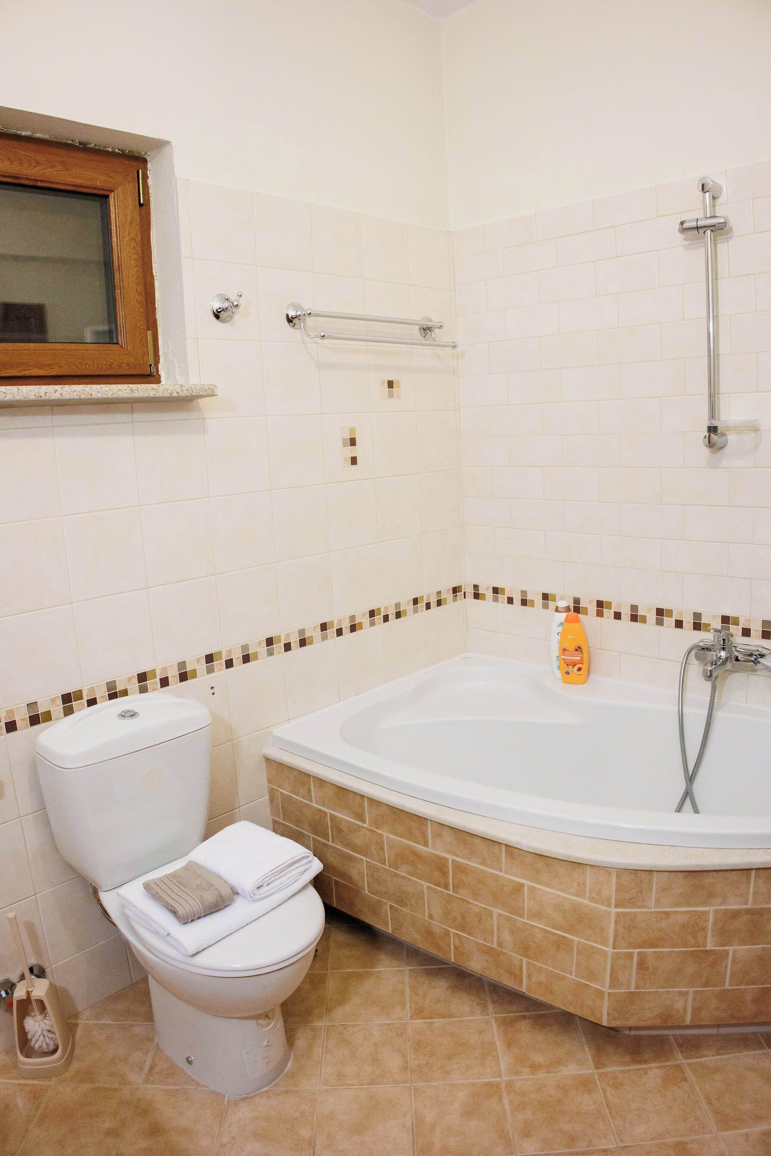 Une salle de bain équipée de toilettes, d’une baignoire et d’une douche.