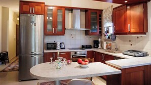 Una cocina moderna con armarios de madera, electrodomésticos de acero inoxidable y encimera de mármol.