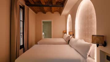 A hotel room with a large bed, two bedside lamps, and a wooden ceiling.