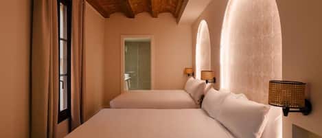 A hotel room with a large bed, two bedside lamps, and a wooden ceiling.