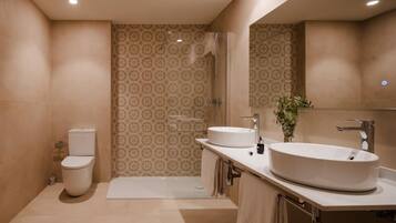 Suite superior, vistas a la ciudad | Baño | Ducha, artículos de higiene personal gratuitos y secador de pelo