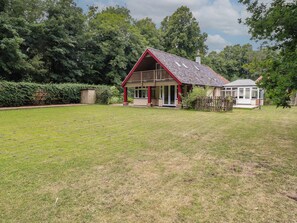A house with a red roof, a porch, and a fenced yard. - The Anchorage (Norwich)