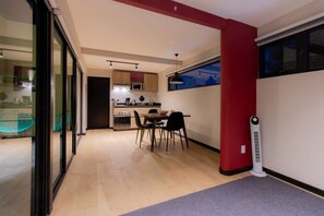 A modern kitchen with a dining area, a red accent wall, and a standing heater. - TOP Escaldon Chic 1BR Apartment (Mexico City)