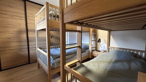 A bunk bed room with a wooden floor, a nightstand with a lamp, and a window. - Luxury apartment 2 bedrooms, Wi-Fi, pets allowed, parking (Arâches-la-Frasse)