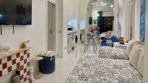 A modern living room with a flat-screen TV, a sofa, a coffee table, and a chandelier. - Midorigami Jacuzzi zen suite Spanish Steps apt. (Roma)
