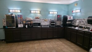 Une cuisine équipée d’un four à micro-ondes, d’une machine à café et d’un réfrigérateur.