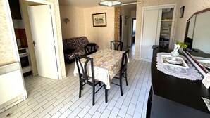 Une cuisine de taille réduite comprenant une table à manger, des chaises et un réfrigérateur.