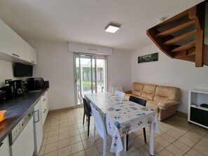A compact kitchen with a dining area, a sofa, and a TV. - Renovated house near Kerfontaine Beach, 6 pers., pets allowed, 3 bedrooms (Sarzeau)