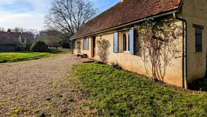 A traditional house with a gravel driveway, a well-maintained lawn, and a clear sky. - Charming accommodation with park and pond in Mers-sur-Indre (Mers-sur-Indre)