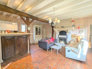 A rustic living room with a fireplace, a dining area with a wooden table, and a cozy seating arrangement. - Charming accommodation with park and pond in Mers-sur-Indre (Mers-sur-Indre)