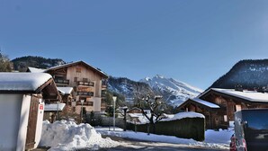 Ein verschneites Bergdorf mit Holzhäusern und klarem Himmel.