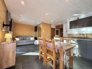 A modern kitchen with dark cabinets and a stainless steel range hood. - Charming studio with alcove - Parking - Praz-sur-Arly (Praz-sur-Arly)