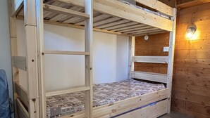 Kerrossänky, jossa on puinen runko ja kukallinen kuviollinen patja.