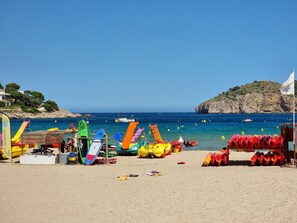 A beach with colorful inflatable water toys and a lifeguard tower. - Studio in L'Escala 300m from beach, pool view (L'Escala)