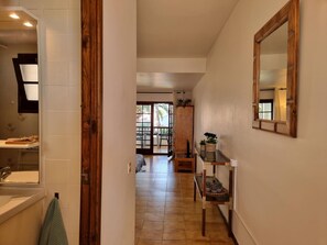 A hallway with a wooden door, a mirror, and a small table with plants. - Studio in L'Escala 300m from beach, pool view (L'Escala)