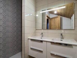 A modern bathroom with two sinks, a large mirror, and patterned wall tiles. - Spacious Duplex Near Center - Pets Allowed (Pralognan-la-Vanoise)