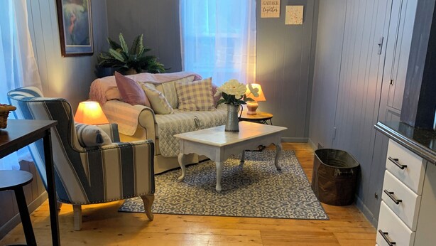 A cozy living room with a sofa, a coffee table, and a dining area with a table and chairs.