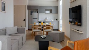 Een moderne woonkamer met een bank, een salontafel en een aan de muur bevestigde televisie.