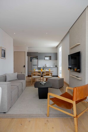Un salon moderne avec un canapé, une table basse et un téléviseur fixé au mur.